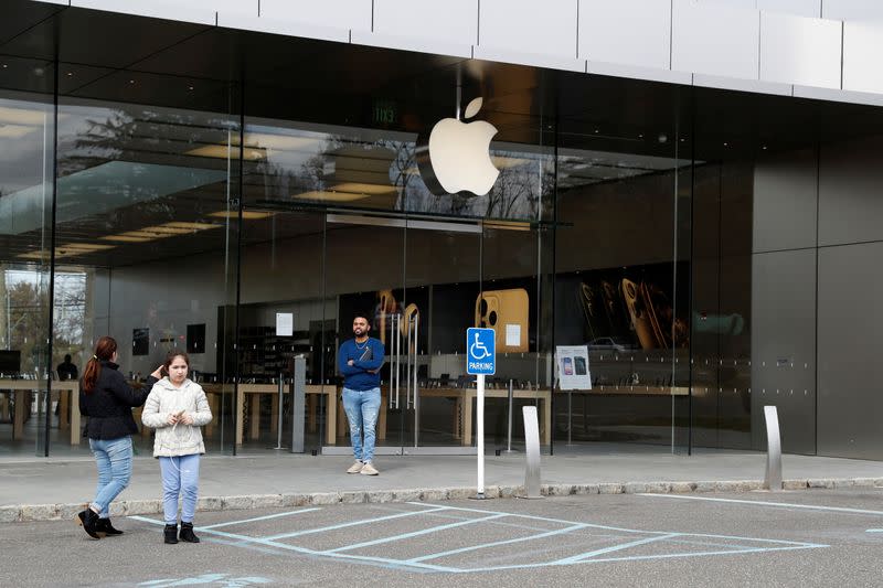 FILE PHOTO: An Apple store employee informs people that the store is closed, after further cases of coronavirus were confirmed in New York, in Manhasset, New York