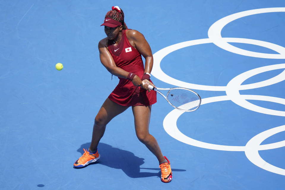 Naomi Osaka, of Japan, returns to China's Zheng Saisai during the tennis competition at the 2020 Summer Olympics, Sunday, July 25, 2021, in Tokyo, Japan. (AP Photo/Patrick Semansky)