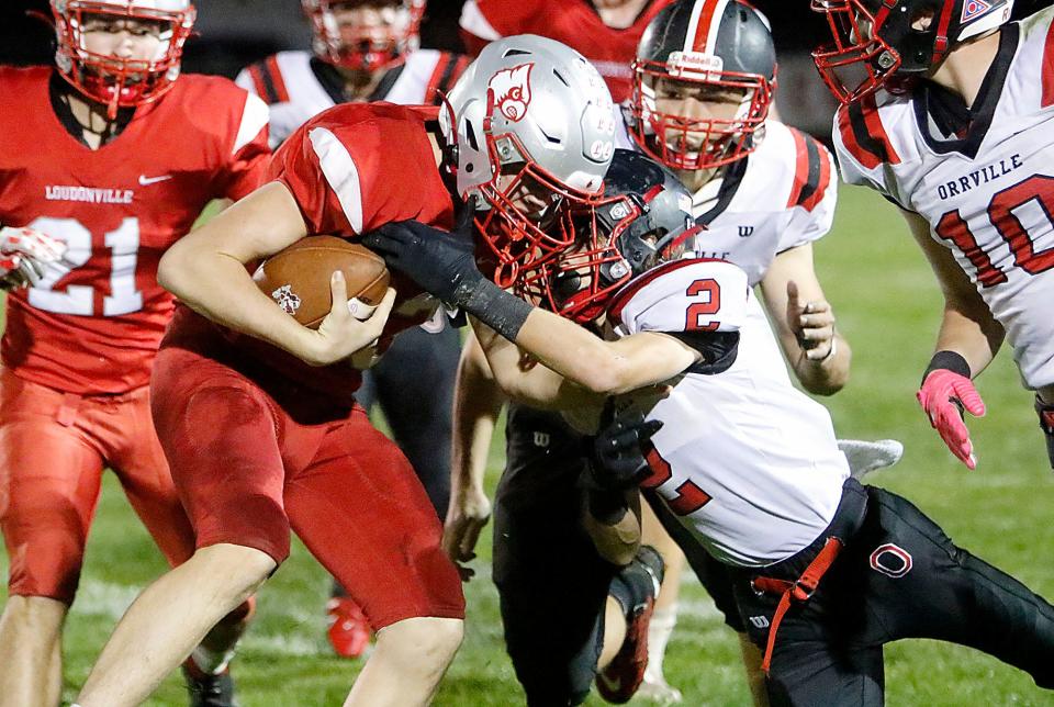 Loudonville High School's Matt Sprang (13) is tackled by Orrville High School's Brady Marshall (2) during high school football action Friday, Oct. 15, 2021 at Loudonville High School's Redbird Stadium. TOM E. PUSKAR/TIMES-GAZETTE.COM