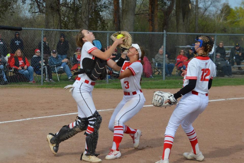 New Boston Huron catcher Emma Sic catches an infield popup while nearly colliding with teammate Erin Newman Wednesday during a win over Airport.