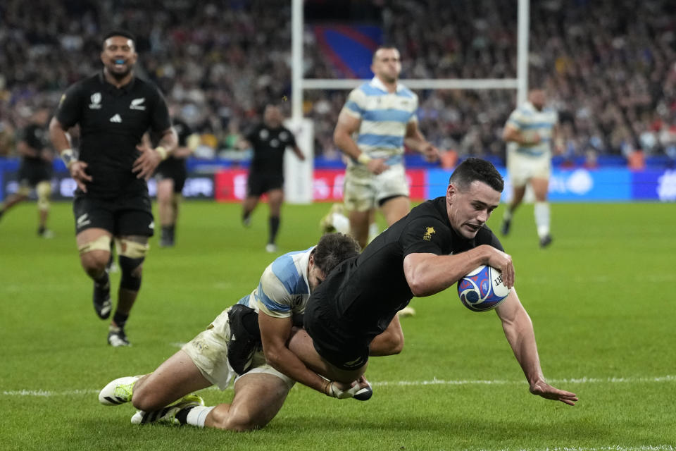 Argentina's Juan Cruz Mallia, left, fails to stop New Zealand's Will Jordan from scoring a try during the Rugby World Cup semifinal match between Argentina and New Zealand at the Stade de France in Saint-Denis, outside Paris, Friday, 20, 2023. (AP Photo/Pavel Golovkin)