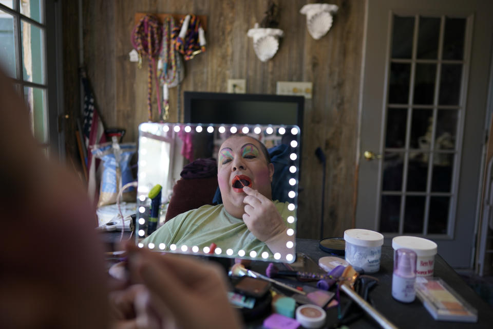 Drag queen Alexus Daniels is reflected in a mirror while applying makeup, or "painting," at home in Coal Township, Pa., on May 6, 2023. (AP Photo/Carolyn Kaster)