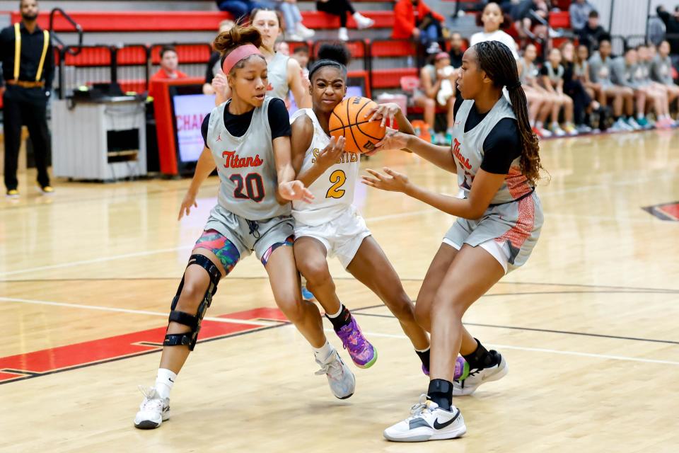 Sand Spring’s Kauri Wilson (2) fights past Carl Albert’s Essence Curry (20) and Audrey Plunkett (23) during the Titan Classic tournament between Carl Albert and Sand Springs in Midwest City, Okla., on Saturday, Jan. 20, 2024.