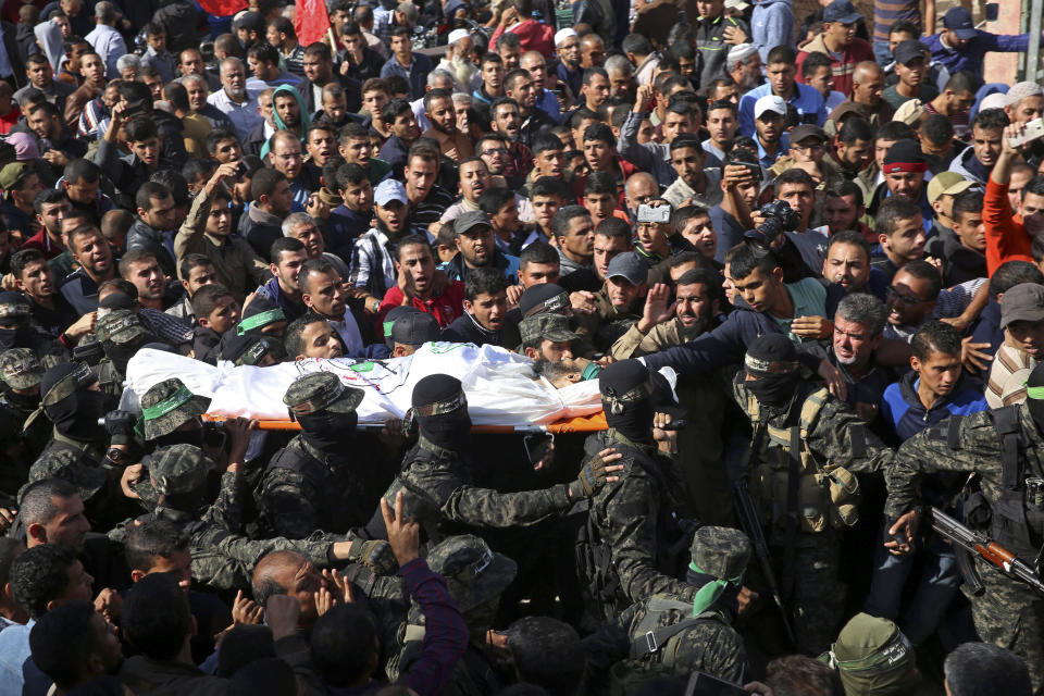 FILE - In this Monday, Nov. 12, 2018 file photo, mourners carry the body of Hamas militant commander Nour Baraka, who was killed during an Israeli raid late Sunday, during his funeral, at his family house in Khan Younis, southern Gaza Strip. A month after a heavy round of Israel-Hamas fighting, the undercover Israeli operation that sparked the battle remains clouded in mystery.(AP Photo/Adel Hana, File)