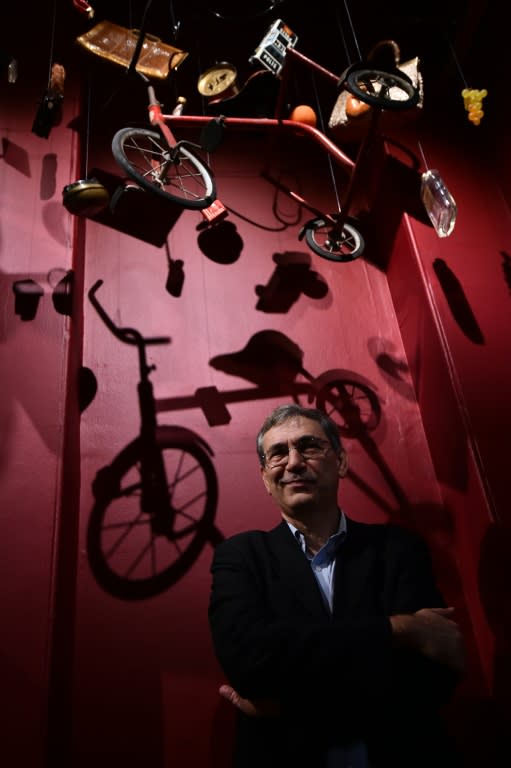 Turkish Nobel Laureate Orhan Pamuk poses with his work of art entitled 'Floating Objects' as part of his exhibition 'The Museum of Innocence' which runs until April 3 his in London, on January 26, 2016