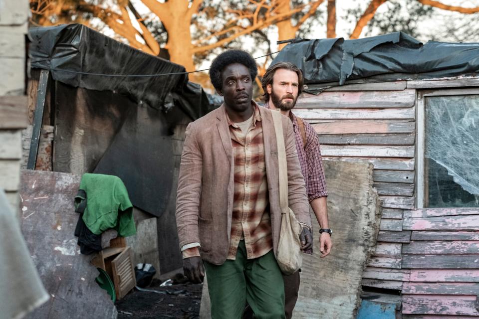 Kabede Bimro (Michael Kenneth Williams, left) and Ari Kidron (Chris Evans) risk their lives to get Ethiopian refugees to Israel in the Netflix movie 