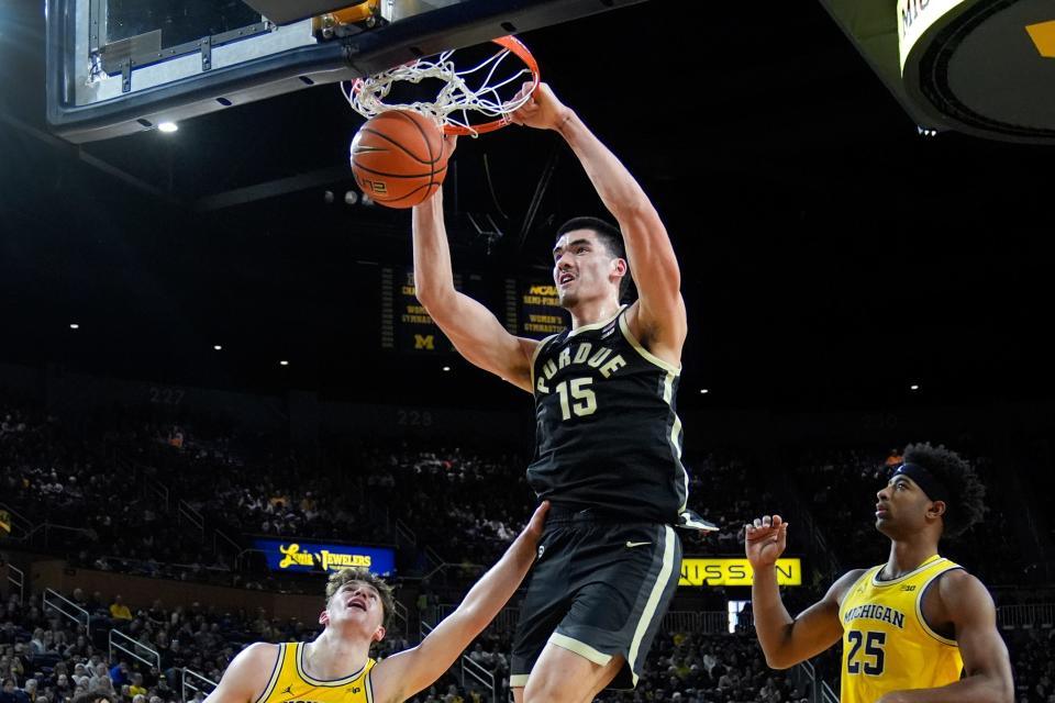 Purdue center Zach Edey (15) dunks on Michigan forwards Will Tschetter (42) and Jace Howard (25) in the first half at Crisler Center in Ann Arbor on Sunday, Feb. 25, 2024.