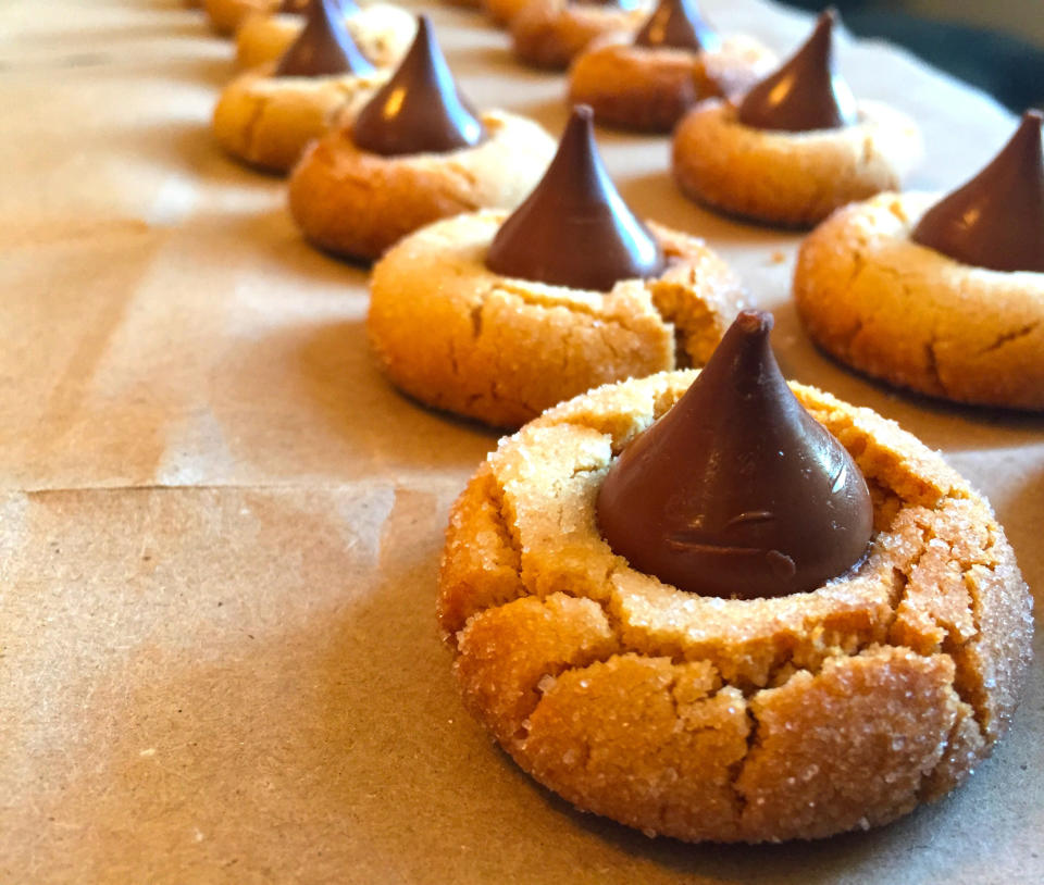 Rows of peanut butter blossom cookies with Hershey's kisses on top.