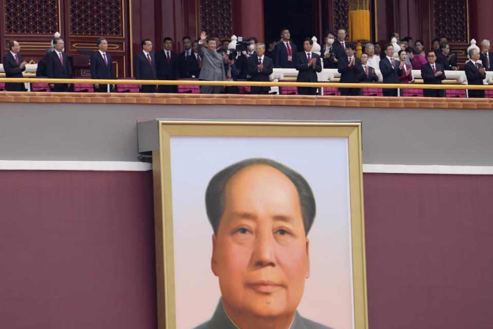 Chinese President Xi Jinping, center, waves above a large portrait of the late leader Mao Zedong during a ceremony to mark the 100th anniversary of the founding of the ruling Chinese Communist Party at Tiananmen Gate in Beijing Thursday, July 1, 2021. (AP Photo/Ng Han Guan)