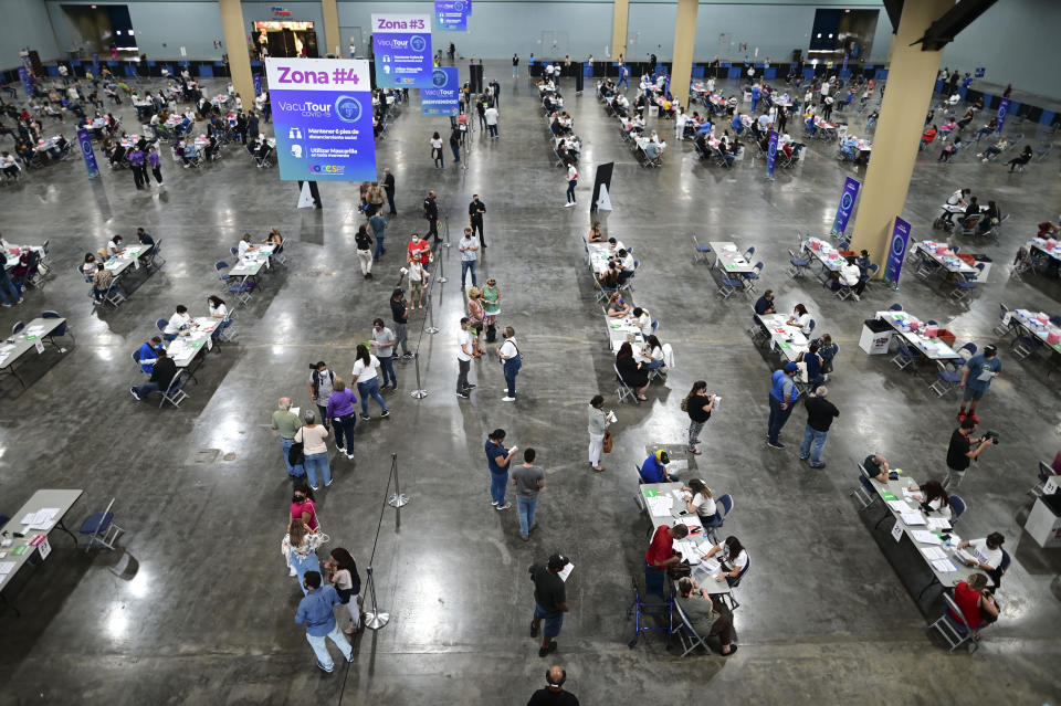 People come in for the first mass vaccination event carried out by the Department of Health and the Voces nonprofit organization, seeking to apply 10,000 Johnson and Johnson vaccines, at the Miramar Convention Center in San Juan, Puerto Rico, Wednesday, March 31, 2021. (AP Photo/Carlos Giusti)