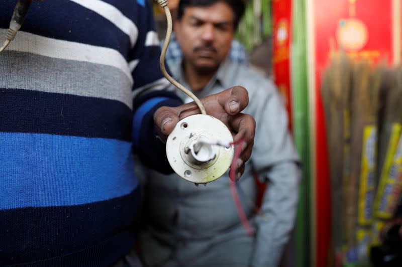 A shopkeeper shows a broken CCTV camera of his shop in Meerut