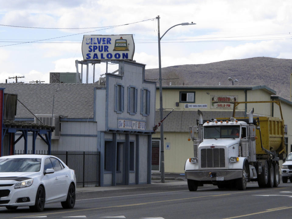 Traffic passes in front of the Silver Spur Saloon on Main Street in Fernley, Nev. about 30 miles east of Reno Thursday, March 18, 2021, The town founded a century ago by pioneers lured to the West with the promise of free land and cheap water is suing the U.S. government over plans to renovate an earthen irrigation canal that burst and flooded nearly 600 homes in Fernley in 2008. (AP Photo/Scott Sonner).