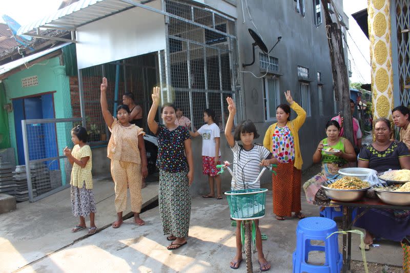 Un grupo de personas hace el saludo con tres dedos mientras personas, protestan contra el golpe militar en Dawei, Myanmar