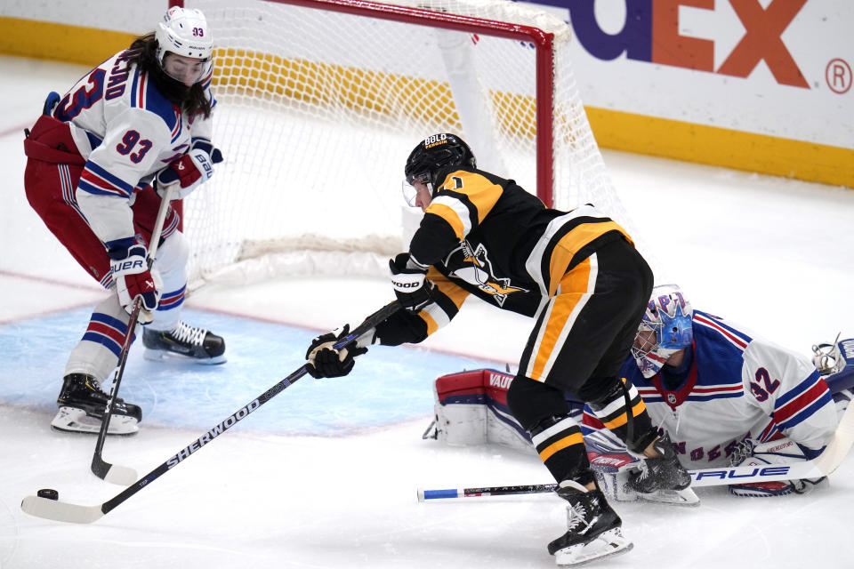 Pittsburgh Penguins' Drew O'Connor can't get his stick on a rebound in front of New York Rangers goaltender Jonathan Quick with Mika Zibanejad (93) defending during the first period of an NHL hockey game in Pittsburgh, Wednesday, Nov. 22, 2023. (AP Photo/Gene J. Puskar)