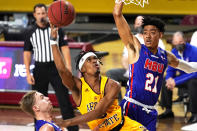 Arizona State guard Caleb Christopher, center, shoots between Houston Baptist guard Ty Dalton, left, and Pedro Castro (21) during the first half of an NCAA college basketball game, Sunday, Nov. 29, 2020, in Tempe, Ariz. (AP Photo/Rick Scuteri)