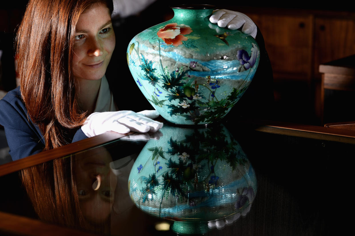 GLASGOW, SCOTLAND - JULY 30:  Natasha Raskin, views a unique Japanese vase made by renowned Japanese artist Kumeno Teitaro, sold for GBP £17,000 in McTears Asian Works of Art sale on July 30, 2013 in Glasgow, Scotland. The vase is an example of Teitaro's famous technique of transparent enamel applied over design in silver. The vase was previously part of Lord and Lady Wark's collection, and has been passed down over the years to the current owner, who has had it in his Glasgow home for some time.  Photo by Jeff J Mitchell/Getty Images)