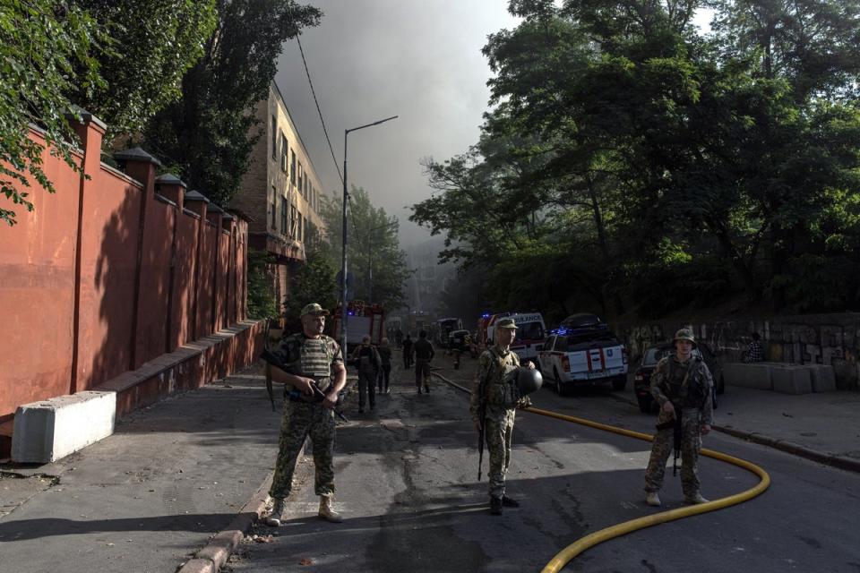 Ukrainian soldiers stand guard in Kyiv’s Shevchenkivsky district after strikes hit the capital (EPA)