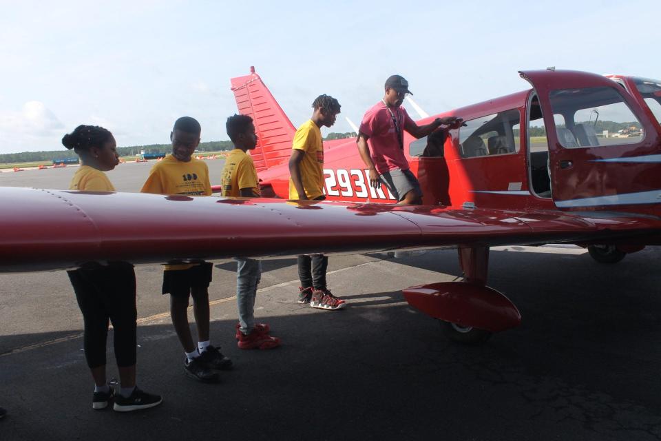 Clinton Cunningham, far right, owner of a 1975 Hybo Archer plane, gives a tour to students at the University Air Center at 4701 NE 40th Terrace on Saturday in Gainesville during the 100 Black Men of Greater Florida GNV's 5th Annual Aviation Academy.
(Credit: Photo by Voleer Thomas/For The Guardian)