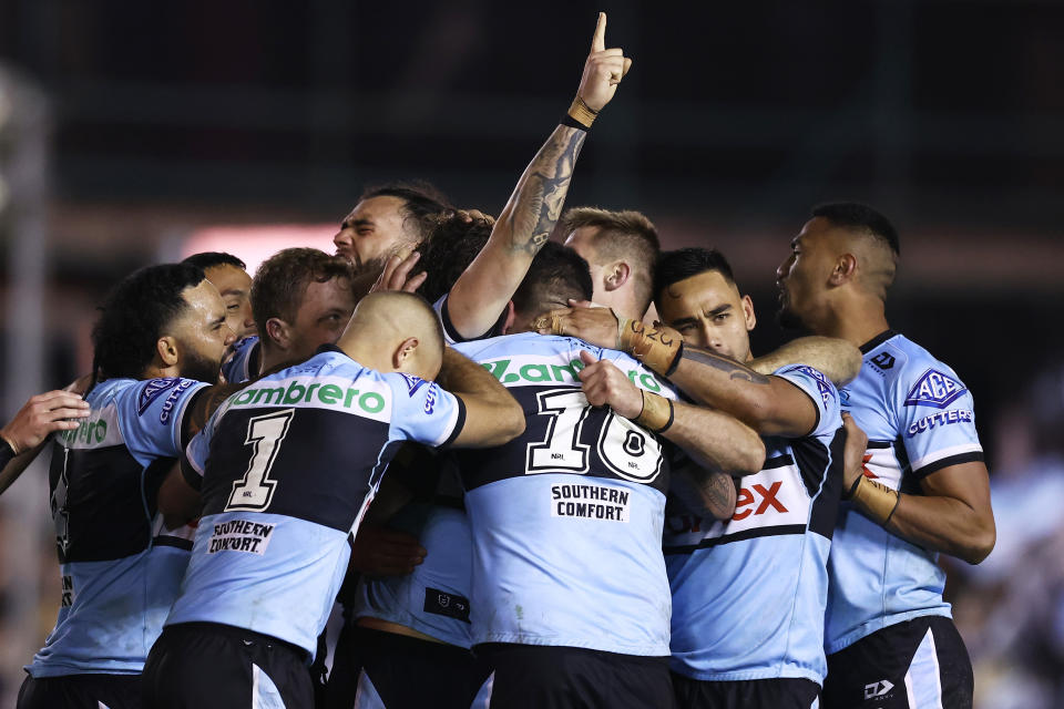 The Sharks celebrate after Nicho Hynes throws his hands up in celebration after kicking the winning field goal.