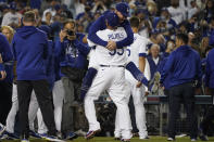 The Los Angeles Dodgers celebrate after Chris Taylor hit a home run during the ninth inning to win a National League Wild Card playoff baseball game 3-1 over the St. Louis Cardinals Wednesday, Oct. 6, 2021, in Los Angeles. Cody Bellinger also scored. (AP Photo/Marcio Jose Sanchez)