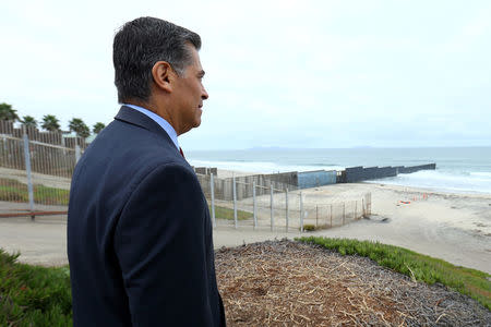 Attorney General of California Xavier Becerra looks out at the U.S.-Mexico border as it enters the Pacific Ocean after announcing a lawsuit against the Trump Administration over its plans to begin construction of border wall in San Diego and Imperial Counties, in San Diego, California, U.S., September 20, 2017. REUTERS/Mike Blake