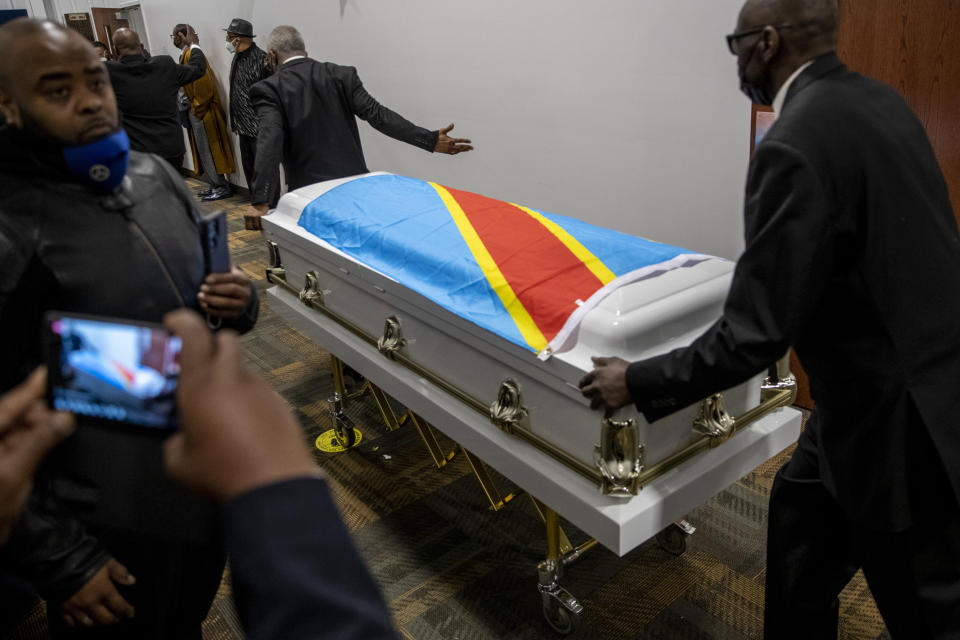 The casket holding the remains of Patrick Lyoya is carted away after the funeral at the Renaissance Church of God in Christ Family Life Center in Grand Rapids, Mich. on Friday, April 22, 2022. The Rev. Al Sharpton demanded that authorities publicly identify the Michigan officer who killed Patrick Lyoya, a Black man and native of Congo who was fatally shot in the back of the head after a struggle, saying at Lyoya's funeral Friday: “We want his name!" (Cory Morse/The Grand Rapids Press via AP)