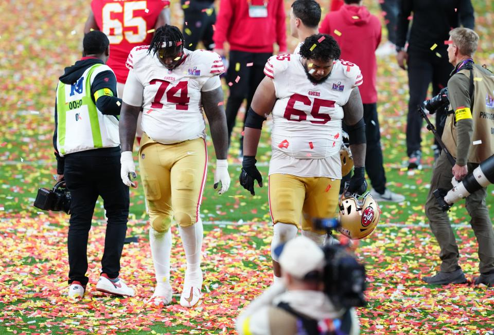 San Francisco 49ers offensive tackle Spencer Burford (74) and San Francisco 49ers guard Aaron Banks (65) leave the field after losing to the Kansas City Chiefs during overtime in Super Bowl LVIII at Allegiant Stadium.