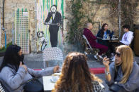 People eat in a restaurant as restrictions are eased following months of government-imposed shutdowns, in Tel Aviv, Israel, Sunday, March 7, 2021. Israel reopened most of its economy Sunday as part of its final phase of lifting coronavirus lockdown restrictions, some of them in place since September. (AP Photo/Ariel Schalit)