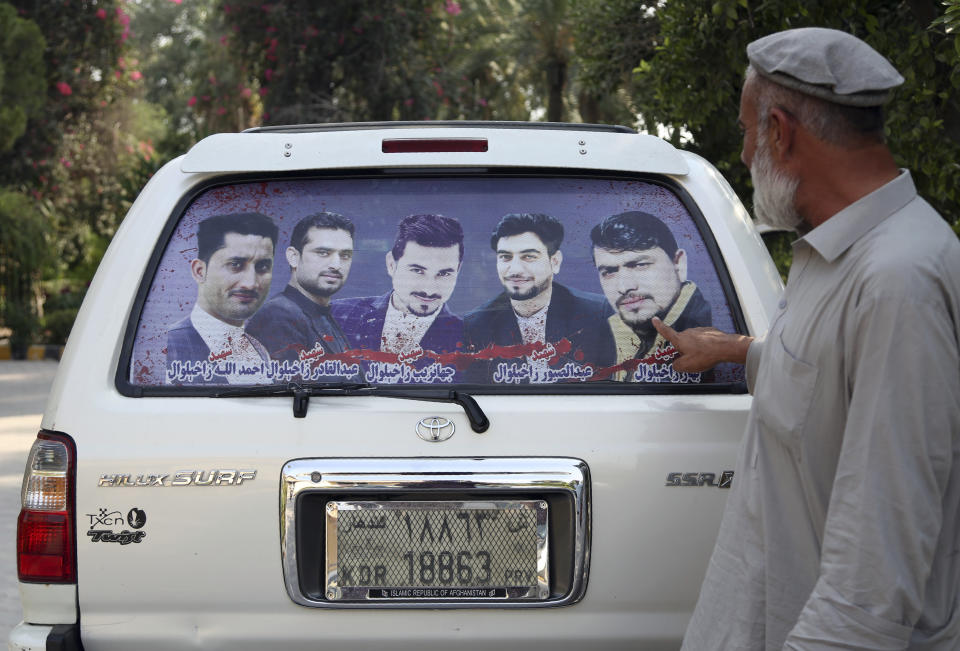 In this Tuesday, Oct. 1, 2019, photo, Zakhiwal's uncle, Mohammad Yaqoob Malikzada shows pictures of four brothers in the back of his car, who ware killed during a raid by the Afghan soldiers trained by CIA only known as Unit 02 after an interview to the Associated Press in Jalalabad city east of Kabul, Afghanistan, Anger is mounting over the increasing numbers of civilians dying in misdirected US aerial strikes and heavy- handed tactics of CIA-trained Afghan force. Some Afghans calling for Americans to be tried in Afghan courts. (AP Photo/Rahmat Gul)