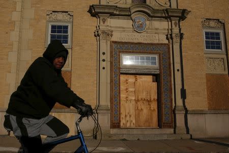 A man rides his bicycle past a boarded up building in Atlantic City, New Jersey, January 19, 2016. REUTERS/Shannon Stapleton