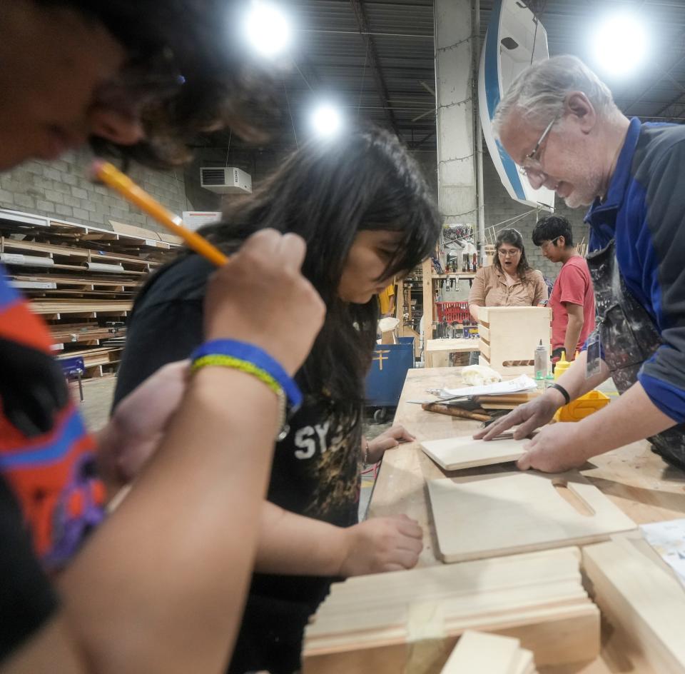 Claire Oliphant, middle, and Johann Morales work together in a hands-on environment Monday, Feb. 5, 2024, at All Hands Boatworks in Milwaukee.