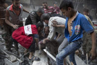 <p>Syrians surround a man as he cries over the body of his child after she was pulled out from the rubble of a budling following government forces air strikes in the rebel held neighbourhood of Al-Shaar in Aleppo on September 27, 2016. Syria’s army took control of a rebel-held district in central Aleppo, after days of heavy air strikes that have killed dozens and sparked allegations of war crimes. (Karam Al-Masri/AFP/Getty Images)</p>