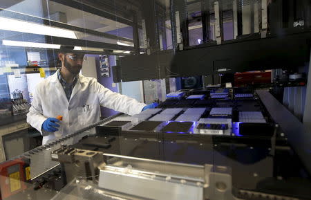 Technician Matthew Smith loads a robotic DNA sample automation machine at a Regeneron Pharmaceuticals Inc. laboratory at the biotechnology company's headquarters in Tarrytown, New York March 24, 2015. REUTERS/Mike Segar