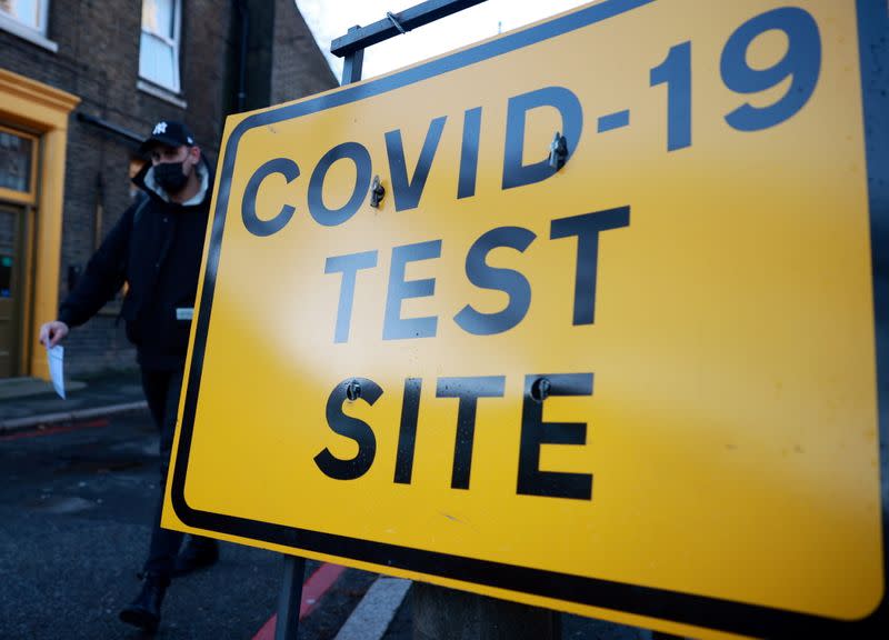 A man walks past a testing site sign, amid the coronavirus disease (COVID-19) pandemic, in London