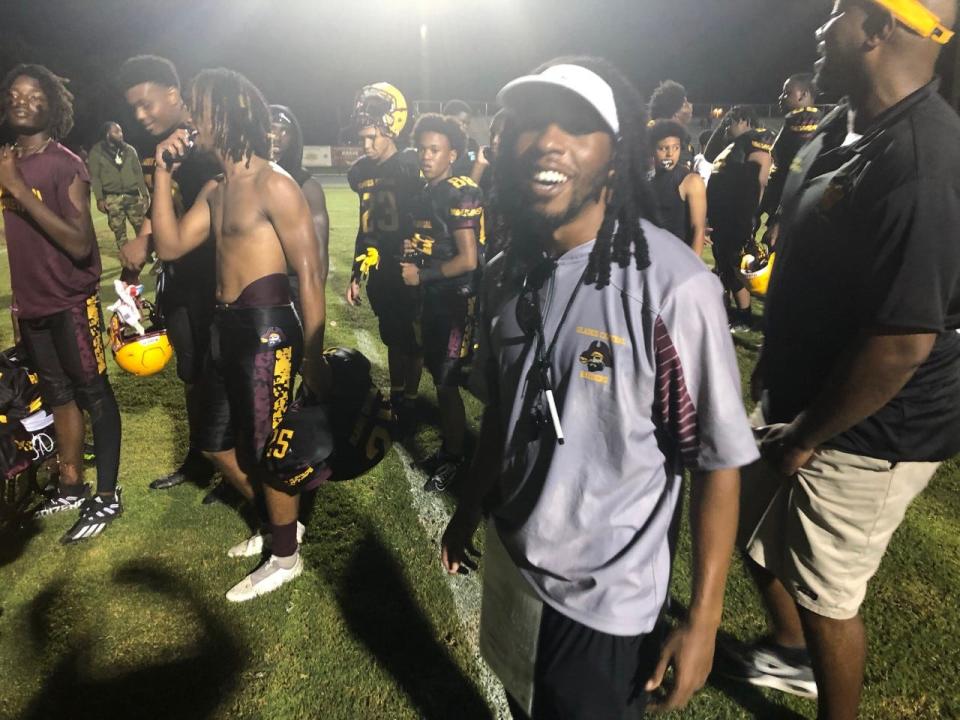 A smiling Glades Central coach Travis Moore leaves the field with his team after posting his first victory as a varsity head coach.