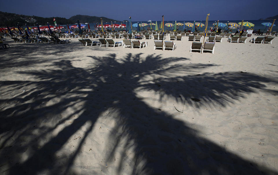 In this March 13, 2014 photo, tourists spend time on Patong Beach in Phuket province, southern Thailand. Thailand’s sapphire blue waters, wildlife parks, delicious cuisine and raunchy red light districts have attracted tourists for decades. Phuket is one of Thailand’s tourism honeypots. Tourists flock here in droves each year for its sun, sand and laid back ambience. And some lose their passports along the way. (AP Photo/Sakchai Lalit)