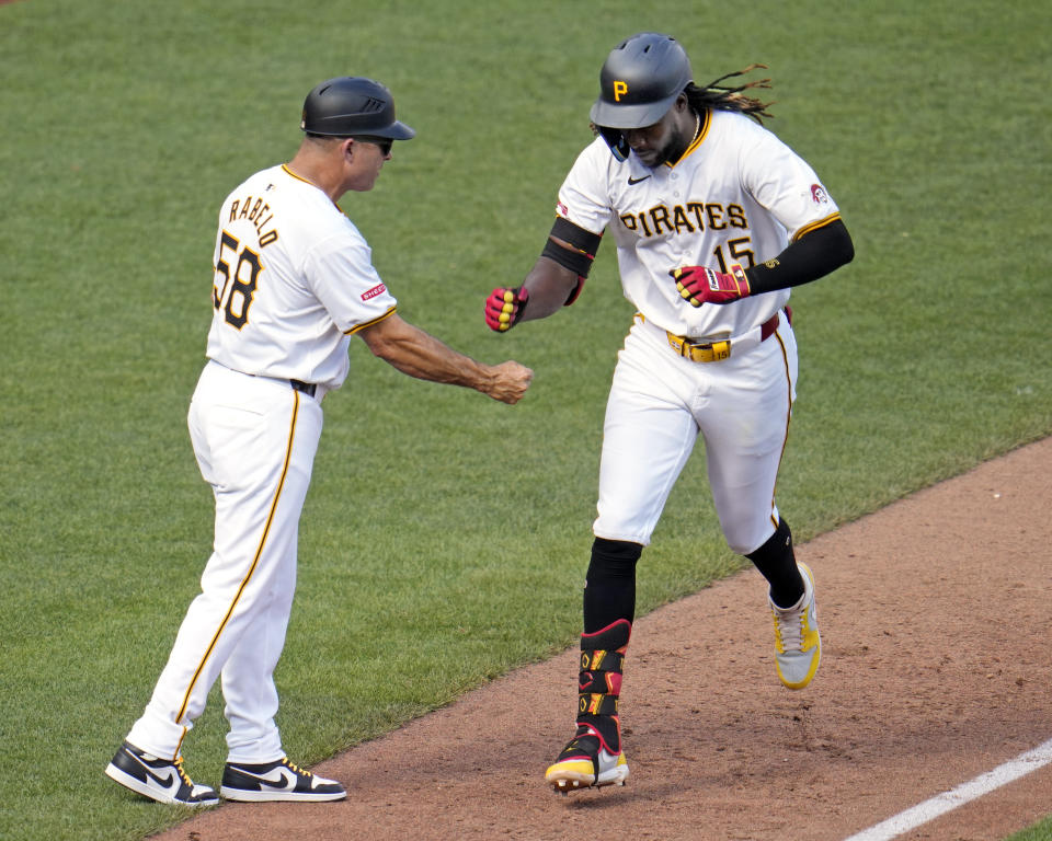 Pittsburgh Pirates' Oneil Cruz (15) rounds third to greetings from third base coach Mike Rabelo, left, after hitting a two-run home run off New York Mets starting pitcher David Peterson during the fourth inning of a baseball game in Pittsburgh, Saturday, July 6, 2024. (AP Photo/Gene J. Puskar)