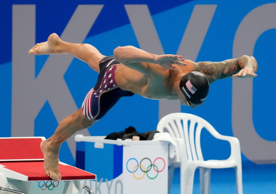 Caeleb Dressel dives into the water at the start of the men's 50-meter freestyle final during the Tokyo Olympics.