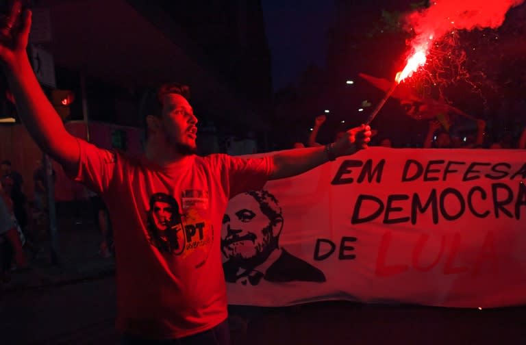 A Lula supporter lights a flare during a demonstration in Porto Alegre