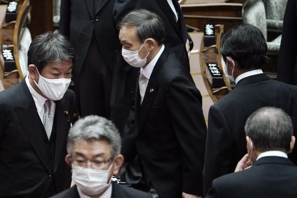 Japan's new Prime Minister Yoshihide Suga, center, walks out after attending an extraordinary session at the upper house of parliament Thursday, Sept. 17, 2020, in Tokyo. Suga started his first full day in office Thursday, with a resolve to push for reforms for the people, and he said he is already taking a crack at it. (AP Photo/Eugene Hoshiko)