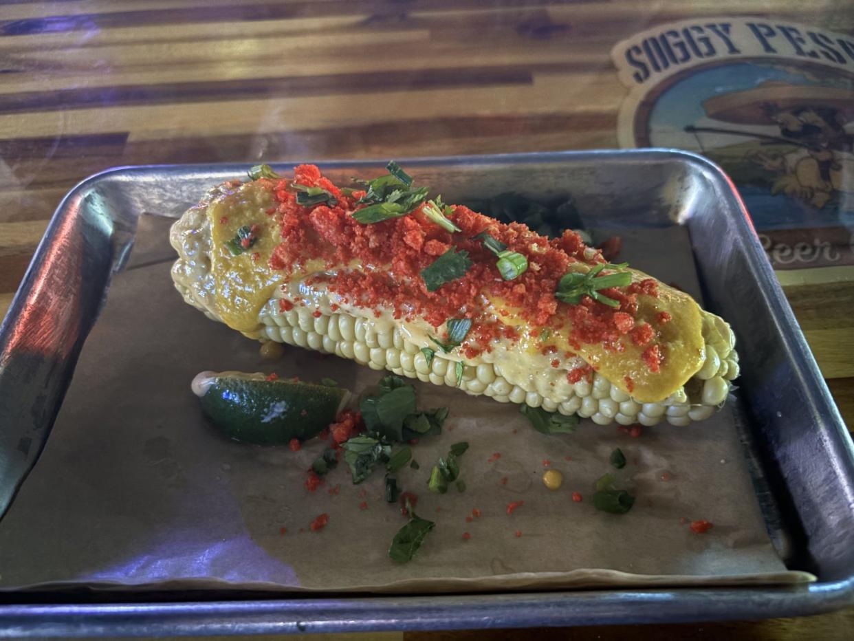 The Street Corn ($8) at Soggy Peso is a tasty surprise, being a whole corn on the cob (and not in a cup) with cotija cheese, mayo, powdered Hot Cheeto, on top of melted cheddar and cilantro and lime wedge. It's definitely worth ordering.