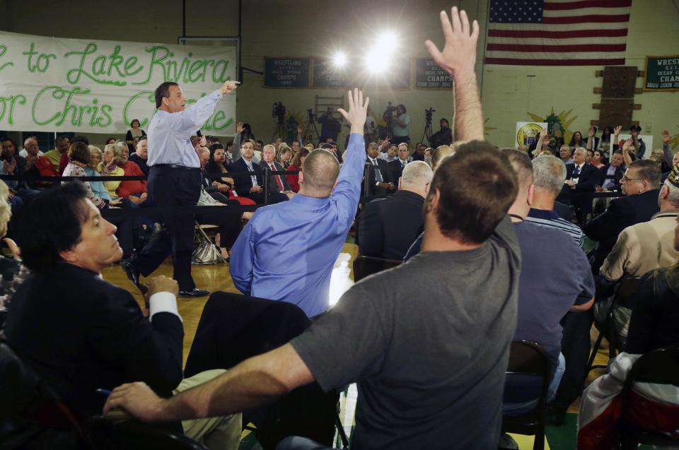 People raise their hands to be recognized by New Jersey Gov. Chris Christie center left, during a town hall meeting in Brick Township, N.J., Thursday, April 24, 2014. Many questions at the town hall focused on the state's Sandy recovery efforts. (AP Photo/Mel Evans)