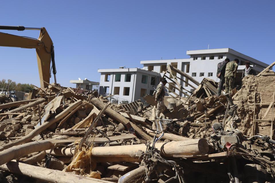 Afghan security inspects the site of a suicide car bombing in Ghor province western of Kabul, Afghanistan, Sunday, Oct. 18. 2020. A suicide car bombing on Sunday killed at least a dozen people and wounded more than 100 others in Afghanistan is western Ghor province officials said. (AP Photo)