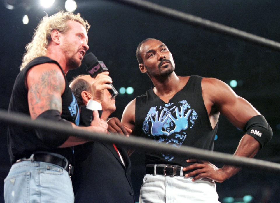 WWE announcer Gene Okerlund, center, at a 1998 wrestling event with Karl Malone, right, and Diamond Dallas Page, left.