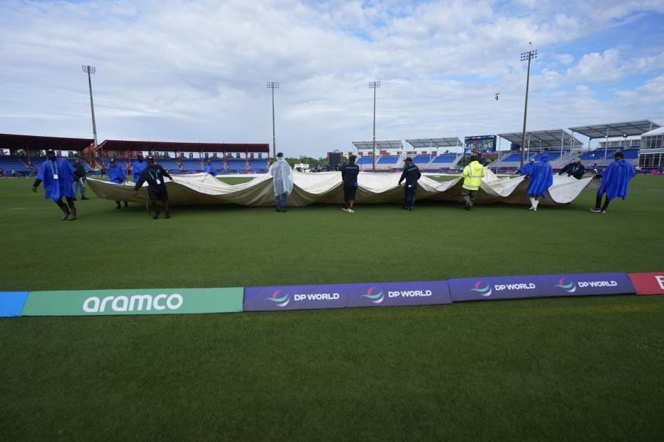 Groundsmen pull the covers off the field before an ICC Men's T20 World Cup cricket match between the United States and Ireland at the Central Broward Regional Park Stadium in Lauderhill, Fla., Friday, June 14, 2024. (AP Photo/Lynne Sladky)