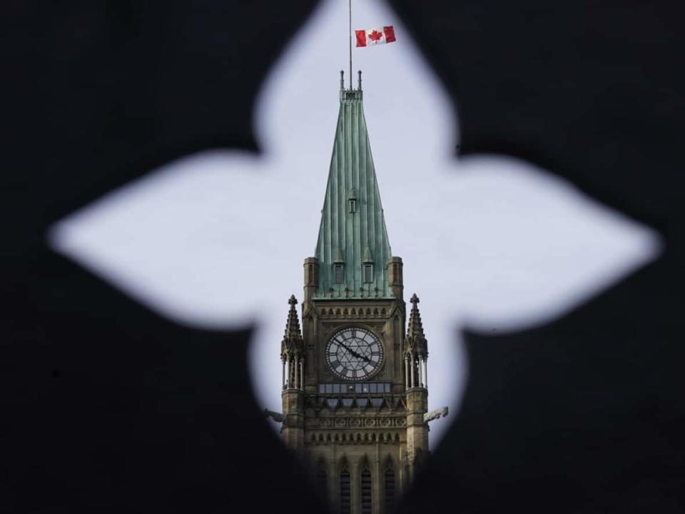 The Canadian flag flies at half mast over the Peace tower and parliament buildings Friday, Oct. 22, 2021. (Adrian Wyld/Canadian Press - image credit)