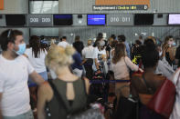 People queue in line to check-in for a British Airways flight to Heathrow airport, Friday Aug.14, 2020 at Nice airport, southern France. British holidaymakers in France were mulling whether to return home early Friday to avoid having to self-isolate for 14 days following the U.K. government's decision to reimpose quarantine restrictions on France amid a recent pick-up in coronavirus infections. (AP Photo/Daniel Cole)