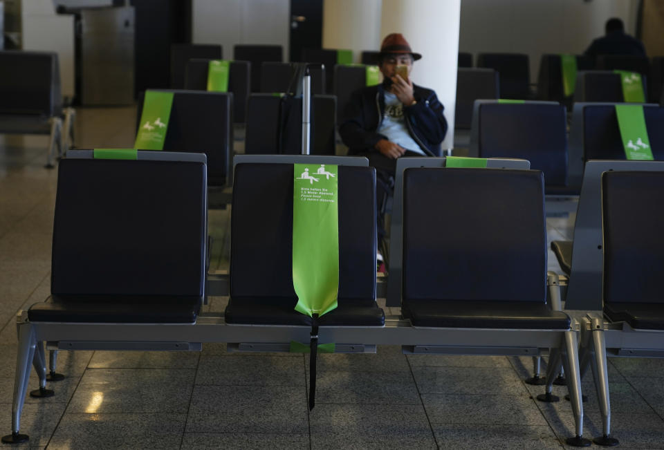 A passenger looks at his phone in Frankfurt, Germany on Sunday, July 18, 2021. (AP Photo/Natacha Pisarenko)