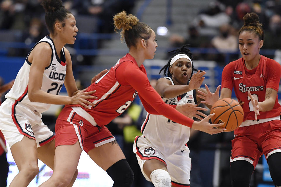 St. John's Rayven Peeples (20) passes to Leilani Correa (2) as Connecticut's Olivia Nelson-Ododa (20) and Christyn Williams (13) defend during the first half of an NCAA college basketball game Friday, Feb. 25, 2022, in Hartford, Conn. (AP Photo/Jessica Hill)