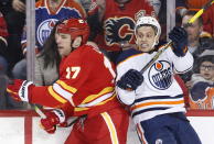 Edmonton Oilers' Caleb Jones, right, reacts to a hit from Calgary Flames' Milan Lucic during the second period of an NHL hockey game Saturday, Jan. 11, 2020, in Calgary, Alberta. (Larry MacDougal/The Canadian Press via AP)